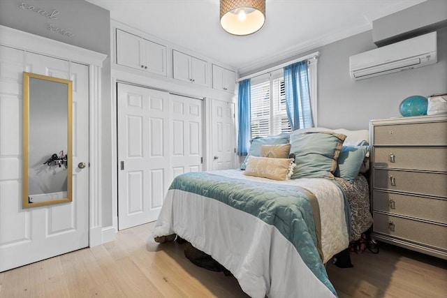 bedroom featuring ornamental molding, a closet, a wall mounted air conditioner, and wood finished floors