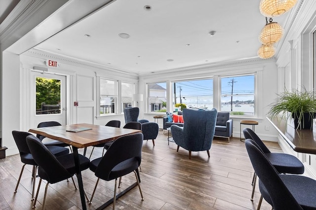 dining room with baseboards, crown molding, and wood finished floors