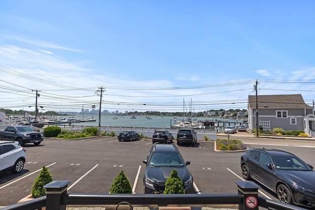 uncovered parking lot featuring a water view