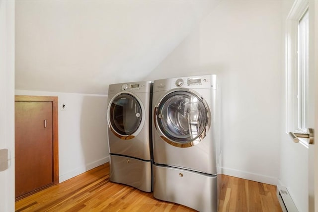 washroom featuring washer and clothes dryer, a baseboard heating unit, light wood-style flooring, and baseboards