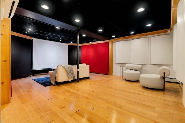 home theater with hardwood / wood-style floors and baseboard heating