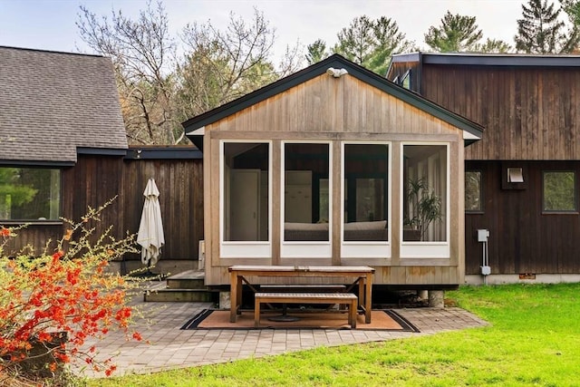 back of property featuring a sunroom and a patio area