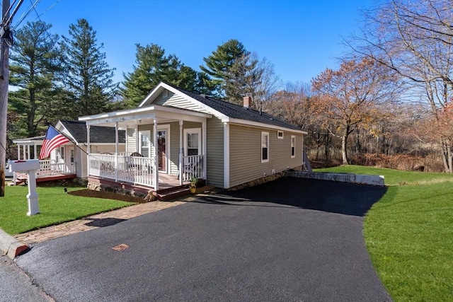 view of front of property featuring covered porch and a front lawn