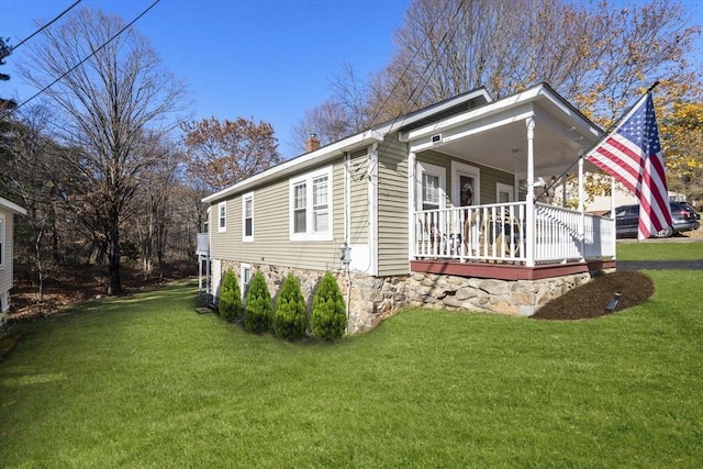 view of side of home featuring a porch and a lawn