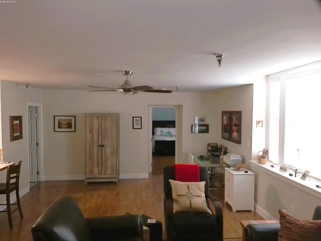 living room with ceiling fan and light hardwood / wood-style floors