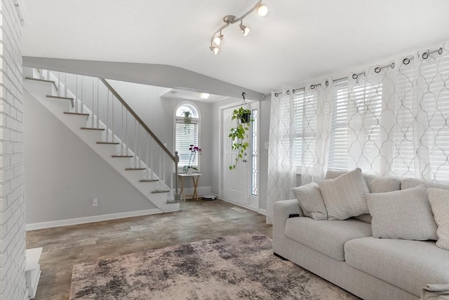living room featuring baseboards, wood finished floors, vaulted ceiling, and stairway