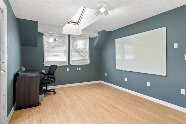 office area featuring a skylight, baseboards, a textured ceiling, and wood finished floors