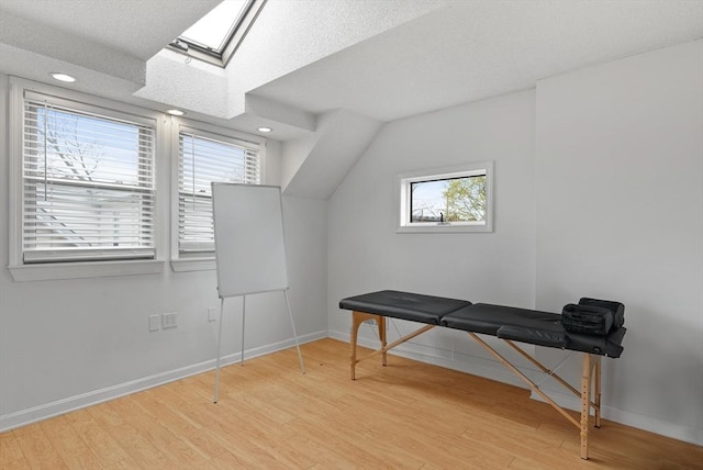 bonus room featuring baseboards, recessed lighting, wood finished floors, and a skylight