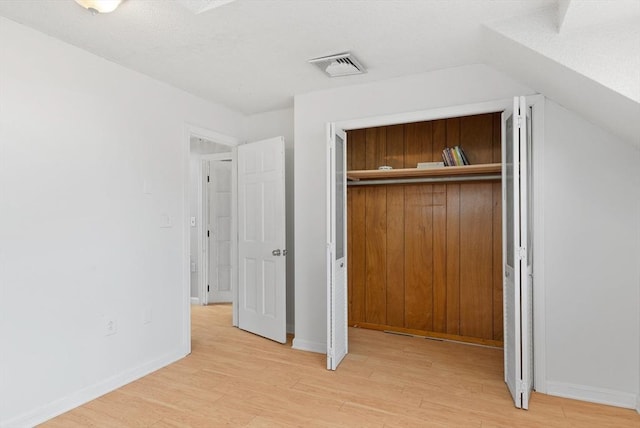 unfurnished bedroom with visible vents, light wood finished floors, baseboards, and a closet