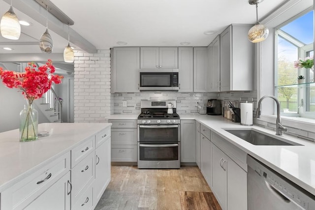 kitchen featuring appliances with stainless steel finishes, gray cabinetry, and tasteful backsplash