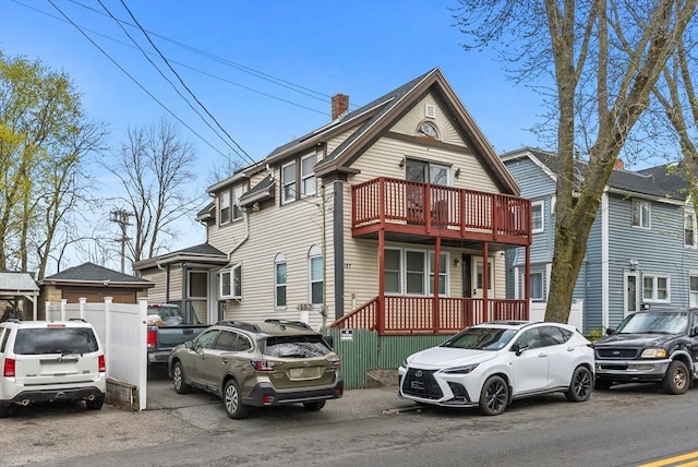 view of front of home featuring a chimney and a balcony