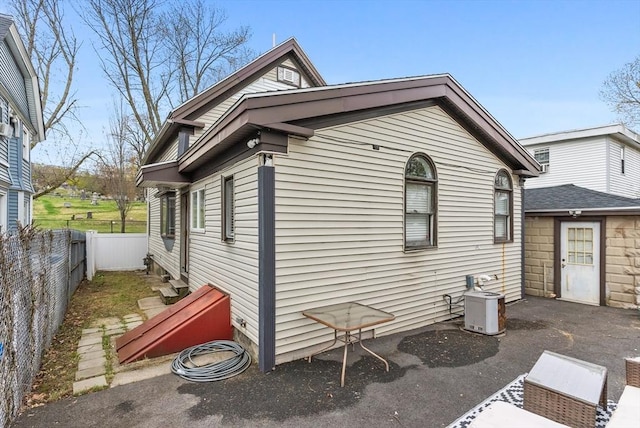 view of side of property featuring a fenced backyard and central air condition unit