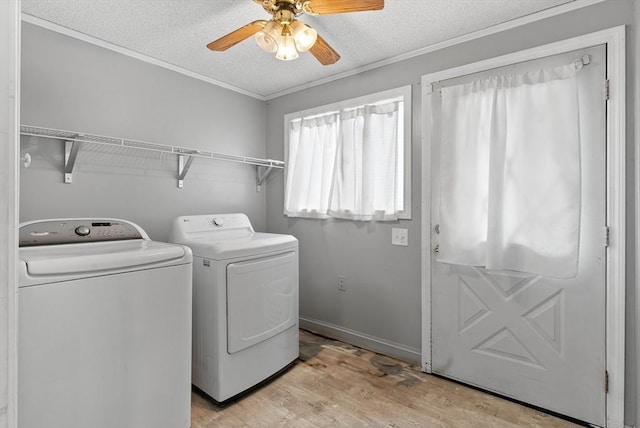 laundry room with ceiling fan, laundry area, a textured ceiling, washing machine and dryer, and light wood-type flooring