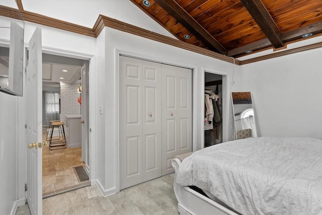 bedroom with wooden ceiling, beamed ceiling, a closet, and light wood-style flooring