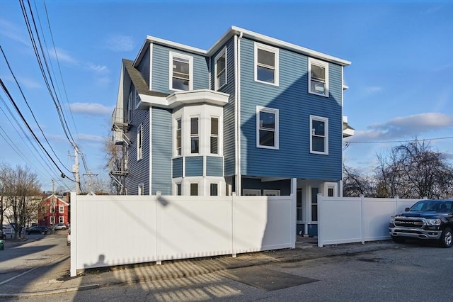 view of front facade featuring fence and uncovered parking