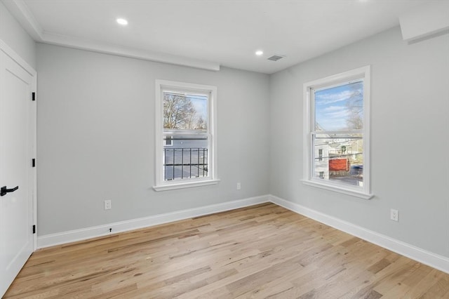 spare room featuring recessed lighting, baseboards, light wood-type flooring, and visible vents