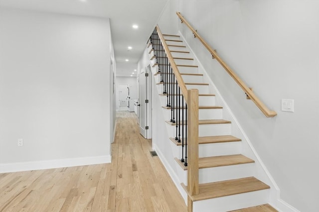 stairs with baseboards, recessed lighting, wood finished floors, and visible vents