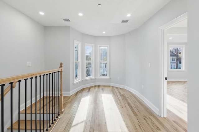 empty room featuring baseboards, light wood-style flooring, and visible vents