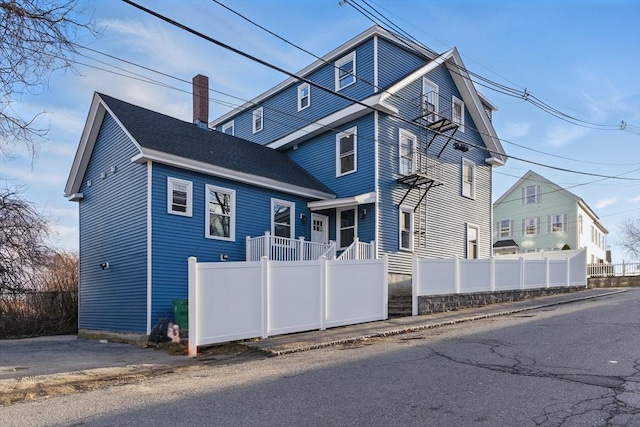 view of front of house with fence and a chimney