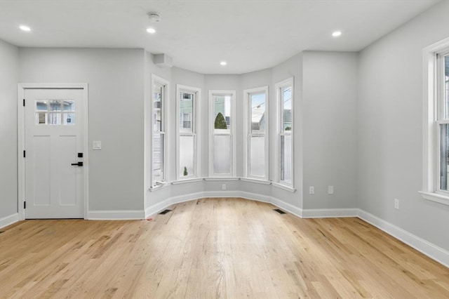 foyer entrance featuring light wood-style floors, plenty of natural light, and visible vents