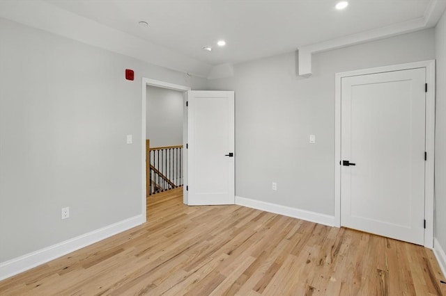 empty room featuring recessed lighting, baseboards, and light wood-style flooring