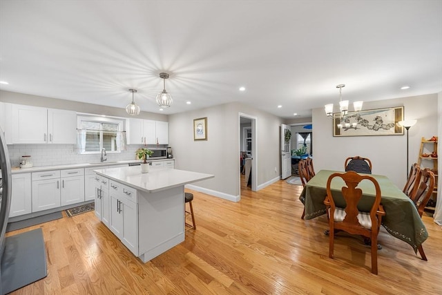 26 Weybosset St, Weymouth, MA 02191 - kitchen featuring stainless steel microwave, a chandelier, light countertops, recessed lighting, and white cabinetry