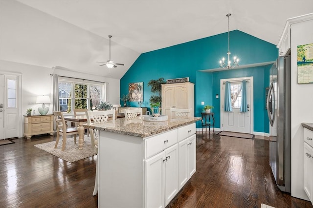 kitchen with lofted ceiling, white cabinetry, dark wood finished floors, and freestanding refrigerator