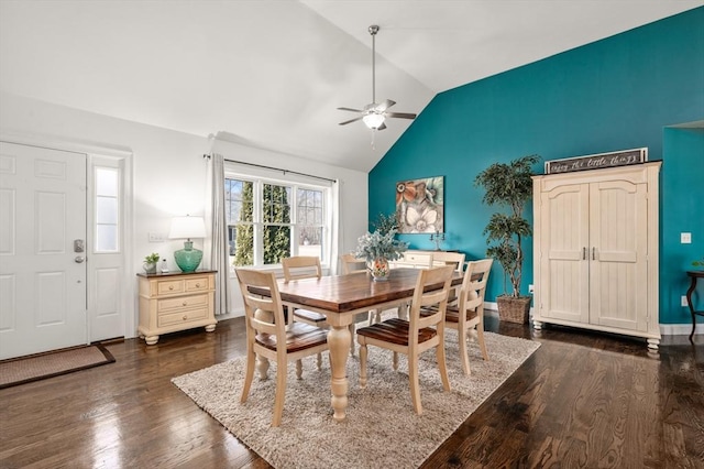 dining space featuring dark wood-type flooring, vaulted ceiling, baseboards, and a ceiling fan