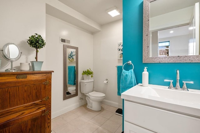 bathroom with visible vents, toilet, vanity, tile patterned flooring, and baseboards