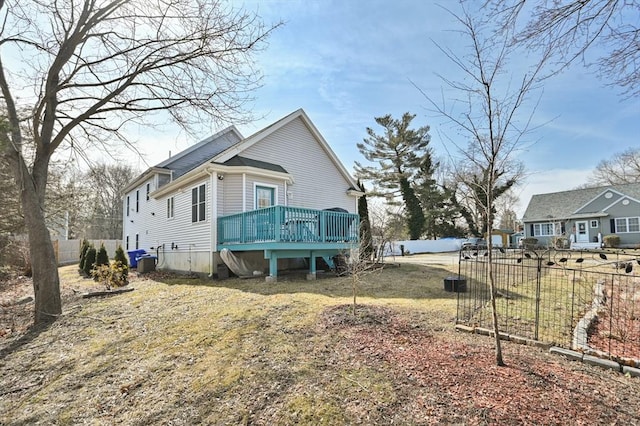 view of property exterior with fence, central AC unit, and a deck