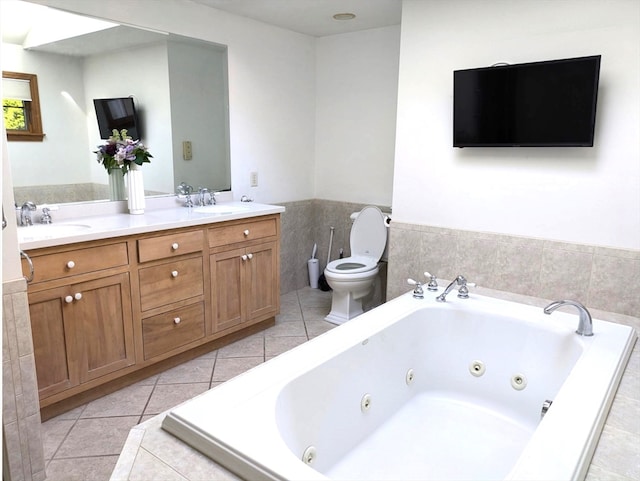 bathroom with a bidet, vanity, tiled bath, tile patterned flooring, and toilet