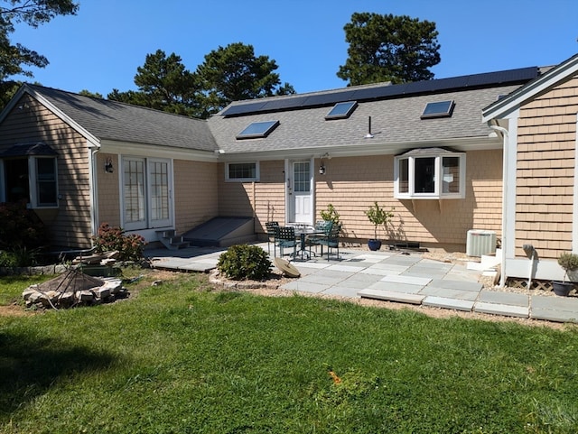 back of property featuring a lawn, solar panels, and a patio area