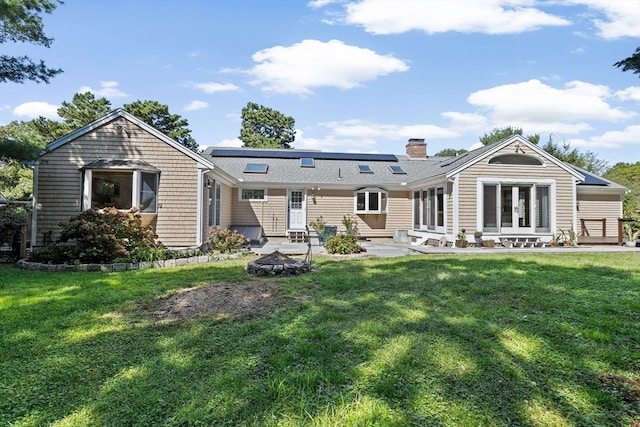 rear view of property featuring a yard and a patio area