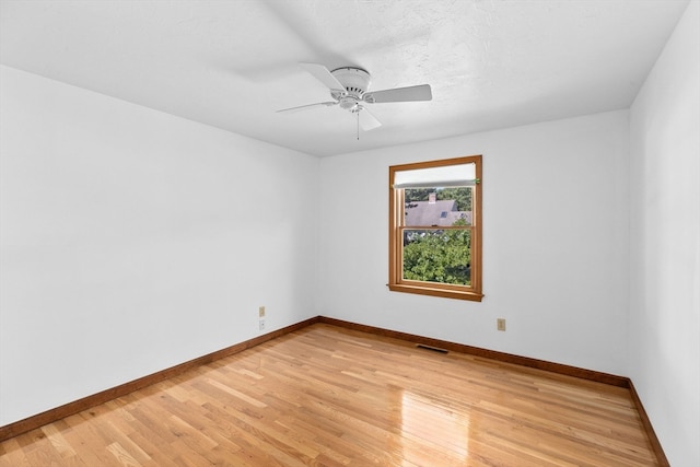 empty room featuring light wood-type flooring, ceiling fan, and a textured ceiling