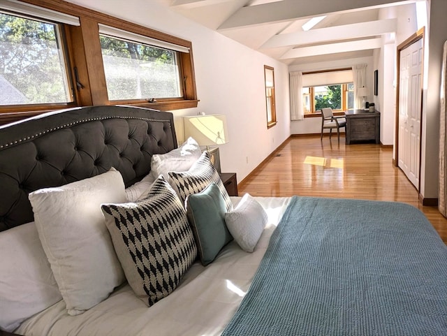 living room with light wood-type flooring and vaulted ceiling with beams