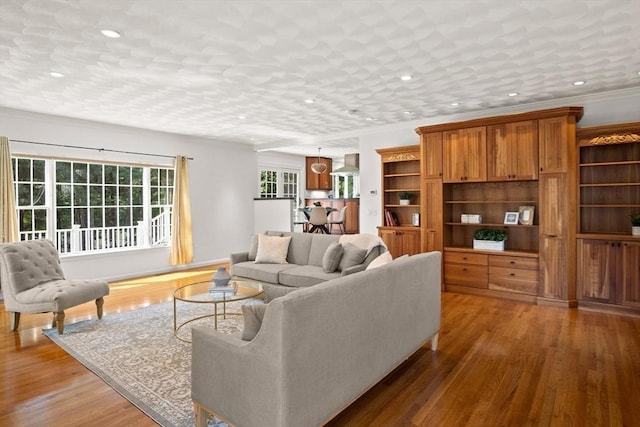 living room with crown molding and hardwood / wood-style floors