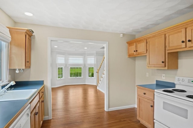 kitchen with sink, light brown cabinets, white appliances, and light hardwood / wood-style flooring