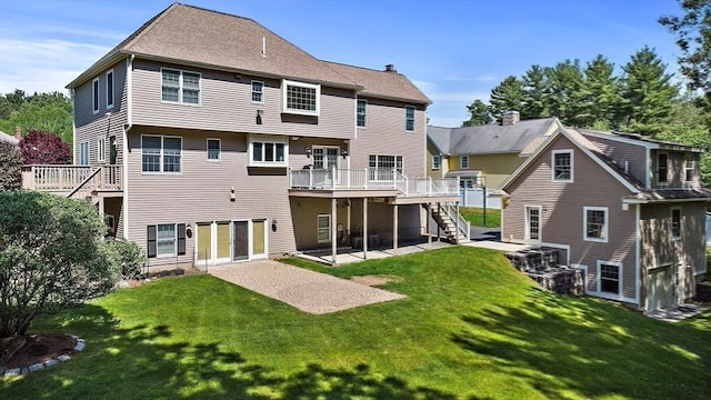 rear view of house featuring a wooden deck, a yard, and a patio