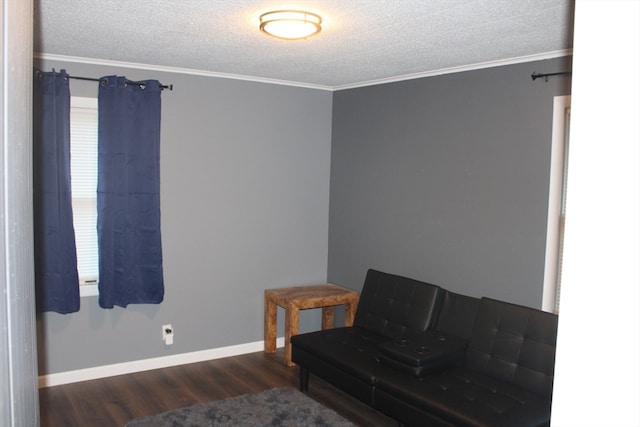 sitting room featuring a textured ceiling, dark hardwood / wood-style floors, and ornamental molding