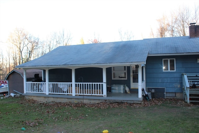 back of house featuring a porch and a yard