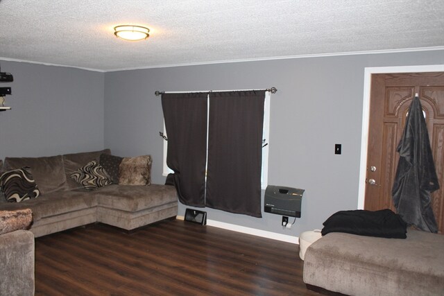 living room with a textured ceiling, dark hardwood / wood-style floors, heating unit, and ornamental molding