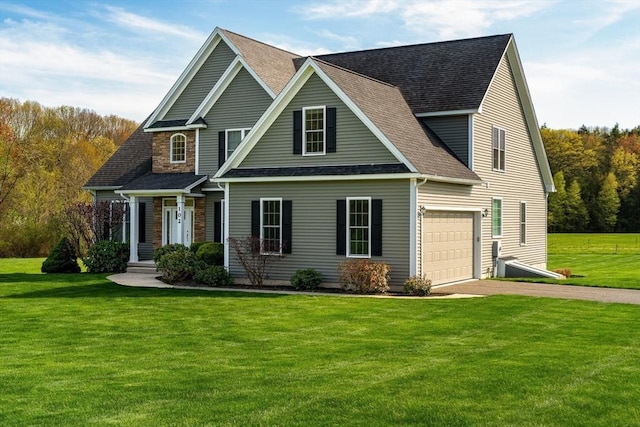 traditional-style home with a front lawn, driveway, roof with shingles, and stone siding