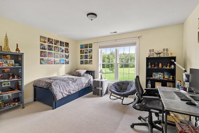 bedroom with carpet flooring and an office area