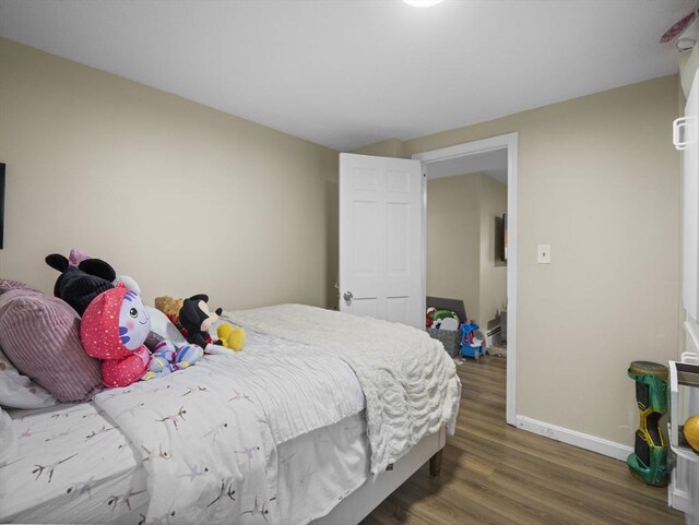 bedroom featuring baseboards and wood finished floors