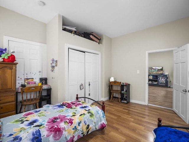 bedroom featuring wood finished floors, a closet, and baseboards