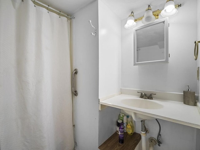 bathroom featuring a sink and curtained shower