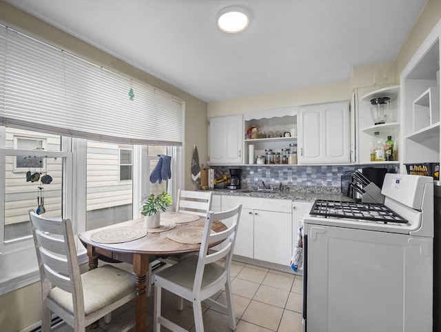 kitchen featuring open shelves, tasteful backsplash, white cabinets, a sink, and white range with gas stovetop