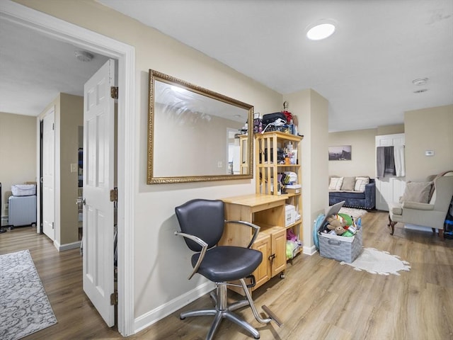 living area with baseboards and wood finished floors
