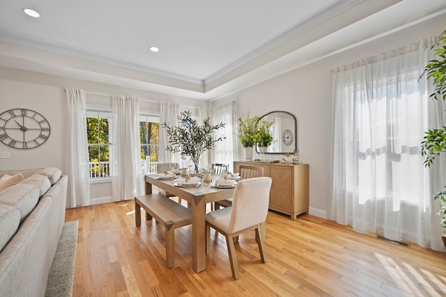 dining area featuring light hardwood / wood-style floors and crown molding