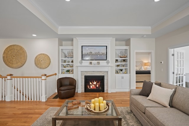 living room with hardwood / wood-style floors, a tray ceiling, and crown molding